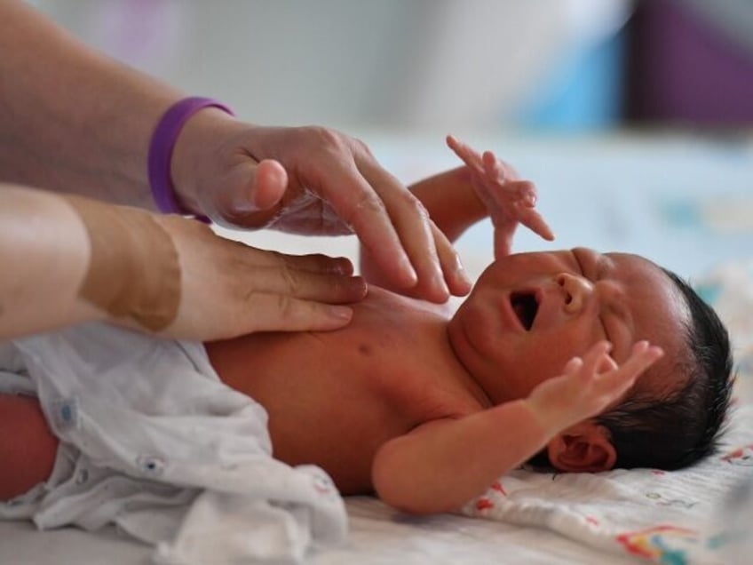 FUYANG, CHINA - AUGUST 08 2022: A nurse massages a newborn baby in a maternity hospital in