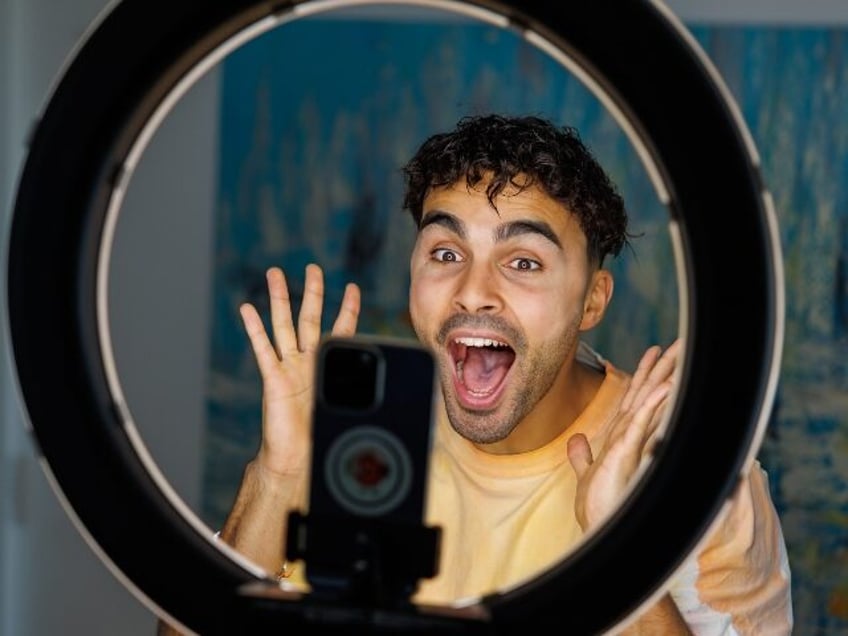gay man filming a TikTok video