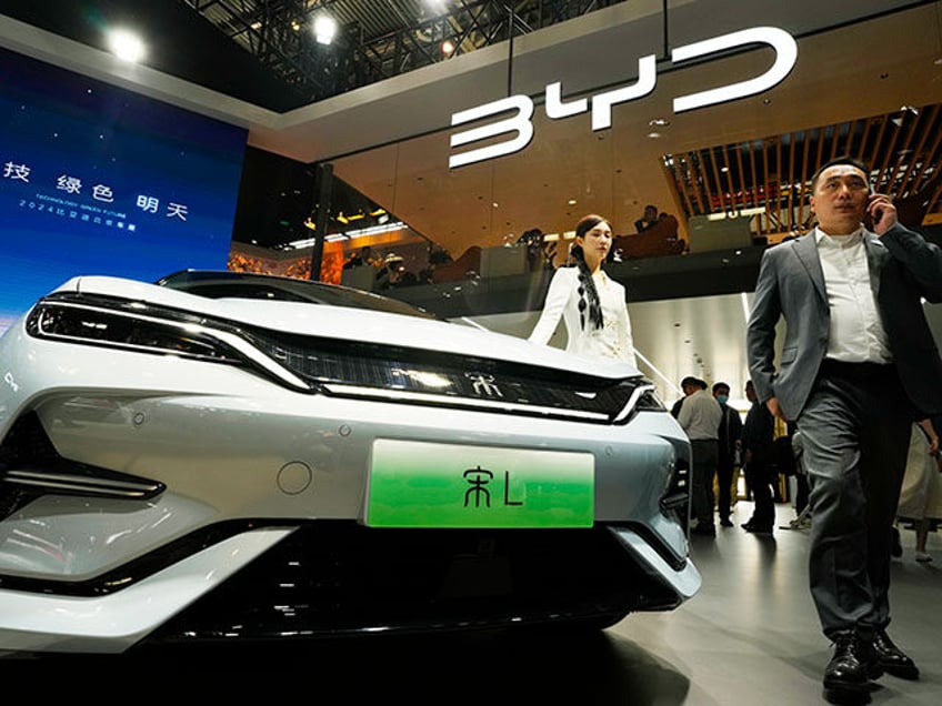 A model poses near the BYD Song L EV car during Auto China 2024 held in Beijing, April 25,