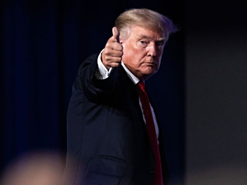 Former US President Donald Trump give a thumbs up as he walks off after speaking at the Co