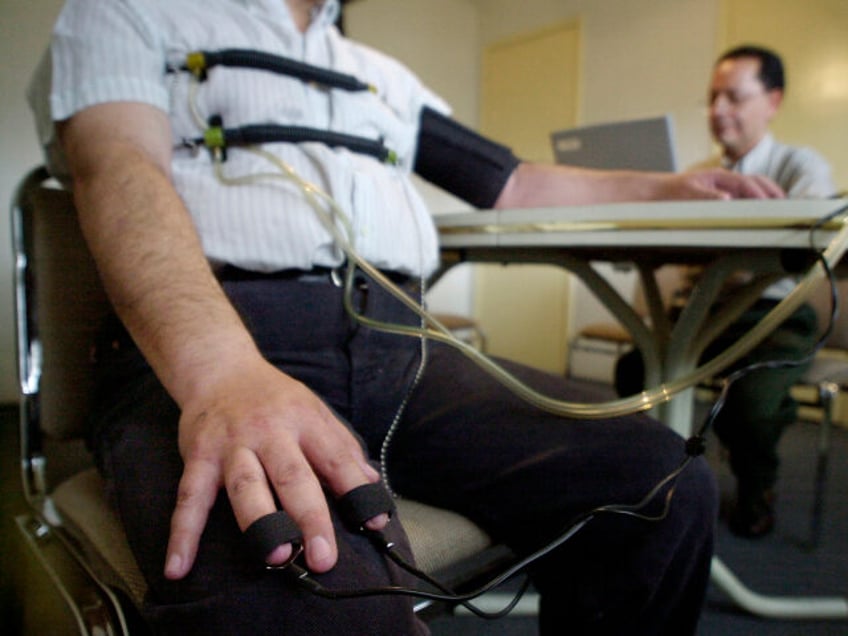 Benjamin Ortiz, right, uses a lie detector to check the background of a security company g