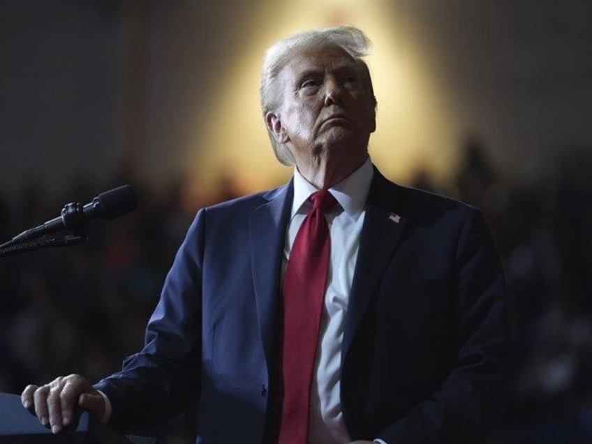 Republican presidential nominee former President Donald Trump watches a video screen at a