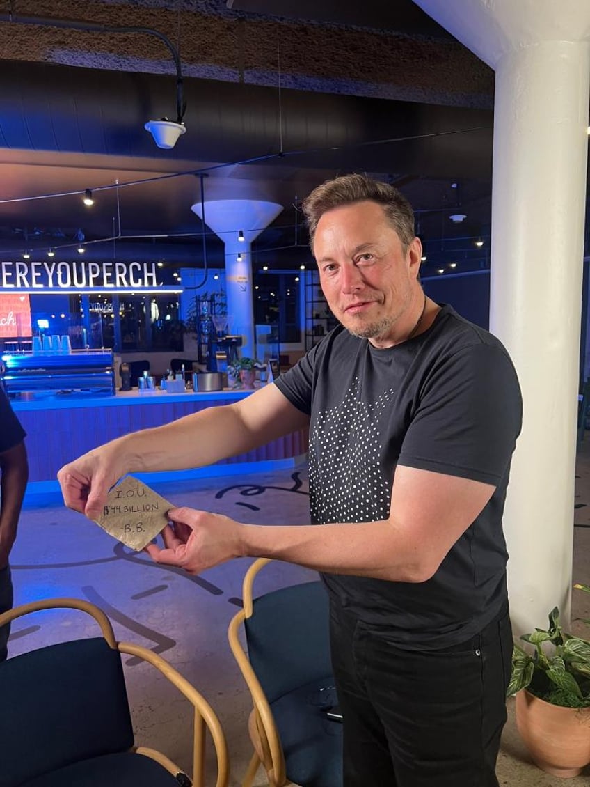 Musk holding the fake "I.O.U" given to him by St. Clair on behalf of the Babylon Bee.