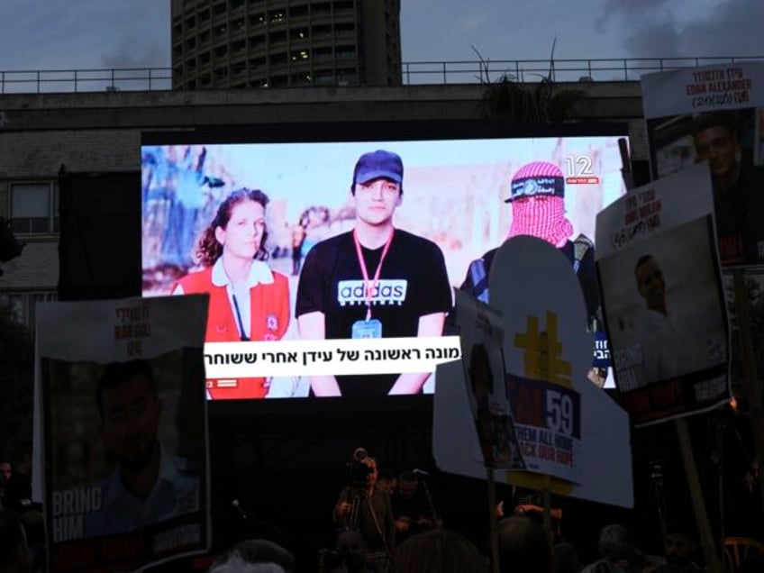 People watch a live broadcast of Israeli-American soldier Edan Alexander as he is released
