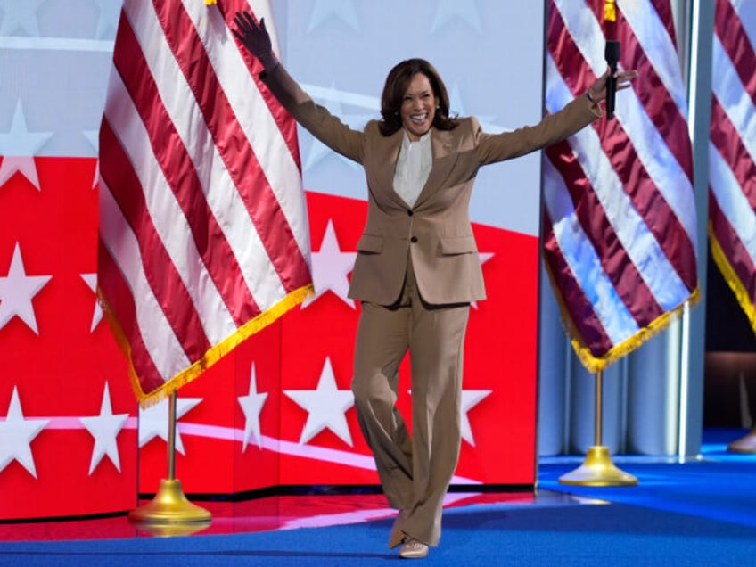 Democratic presidential nominee Vice President Kamala Harris raises her arms as she walks