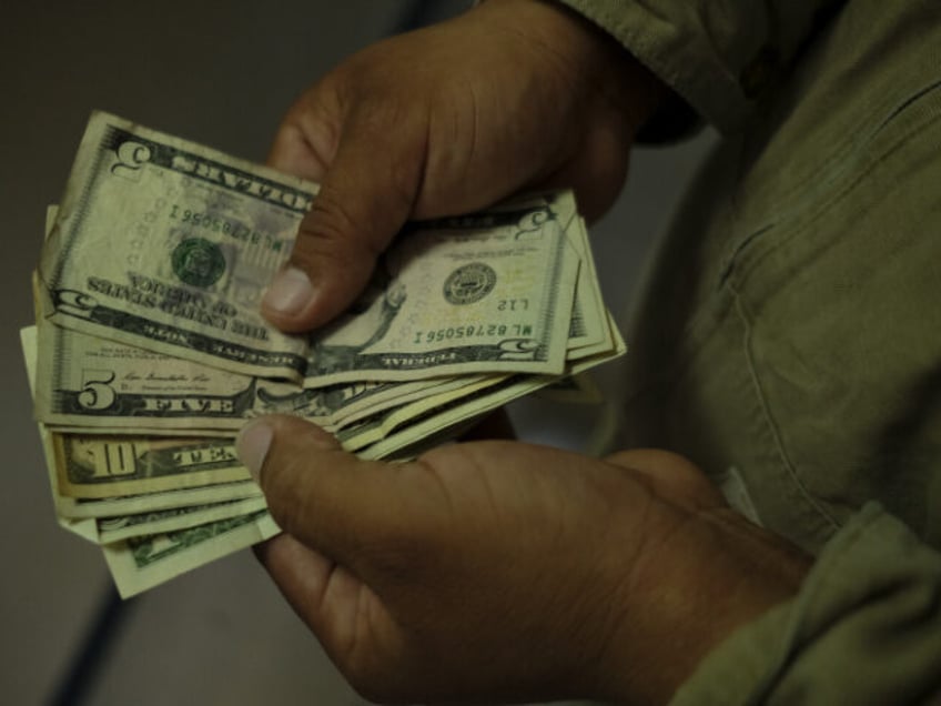 Detail as a Guatemalan returnee prepares to exchange US Dollars for the local currency aft