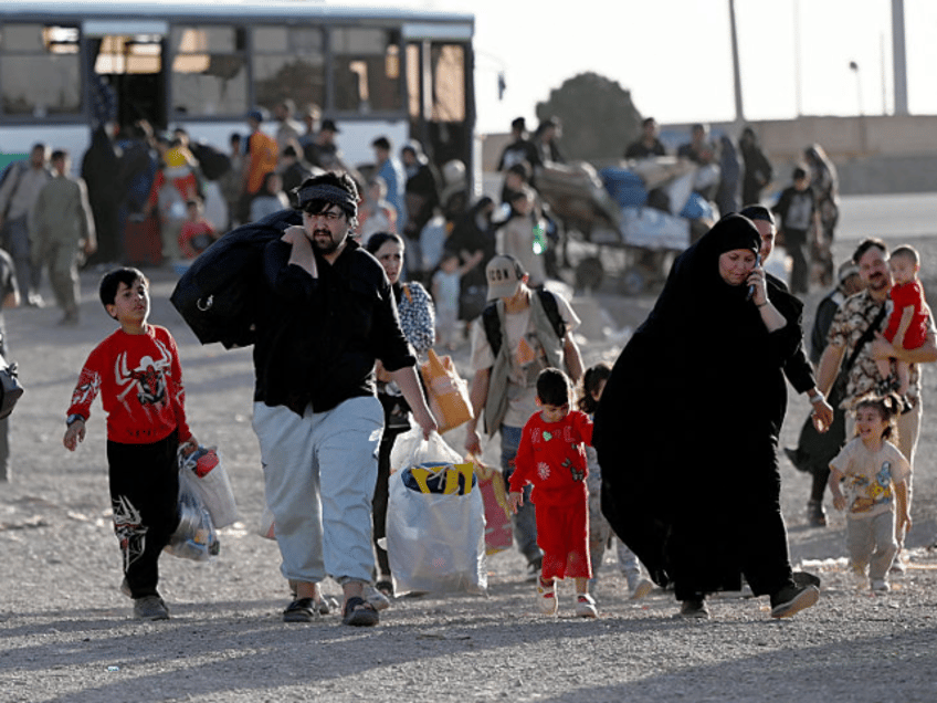 Afghan refugees carrying their belongings arrive at the zero point of the Islam Qala borde