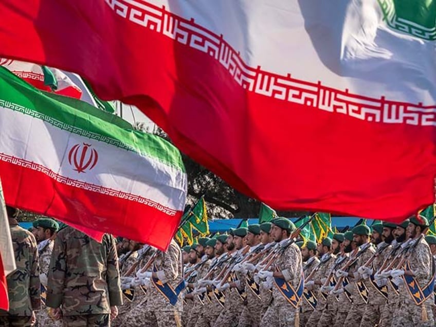 Islamic Revolutionary Guard Corps (IRGC) military personnel march under Iranian flags in a