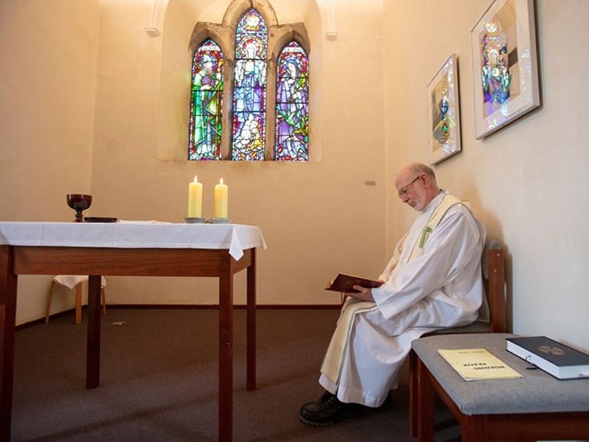 Prior of Lough Derg, Father Laurence (La) Flynn prays inside St Mary's Chapel at St. Patrick's Purgatory on Lough Derg, currently closed to visitors due to the COVID-19 pandemic, near Donegal in Ireland, on July 27, 2020. - As people in Ireland endured months of coronavirus lockdown limbo, priest Laurence Flynn experienced his own private purgatory, keeping solitary vigil on a hallowed island usually crowded with pilgrims. After the nation shut down in late March, Father Flynn became the sole inhabitant of St. Patrick's Purgatory on Lough Derg, a lake in County Donegal said to be where Christ showed Ireland's patron saint the entrance to hell. Dating back to the fifth century, the holy site on Station Island is a place of Catholic pilgrimage where the faithful usually flock for three days of fasting, barefoot prayer and all-night vigils. (Photo by Paul Faith / AFP) (Photo by PAUL FAITH/AFP via Getty Images)