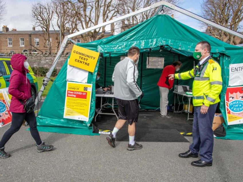 A health worker directs people at a walk-in portable testing centre for Covid-19 operated by the ambulance service in Dublin, Ireland on March 25, 2021, as the country struggles to reduce the spread of coronavirus. (Photo by Paul Faith / AFP) (Photo by PAUL FAITH/AFP via Getty Images)