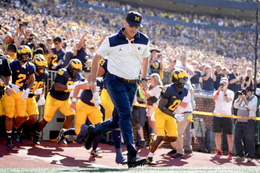 report jim harbaugh to receive credit for wins despite suspension