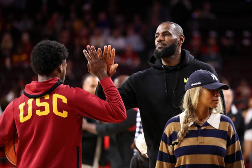 Bronny James of the USC Trojans greets his dad, LeBron James of the Los Angeles Lakers, before the game against the Stanford Cardinal at Galen Center...