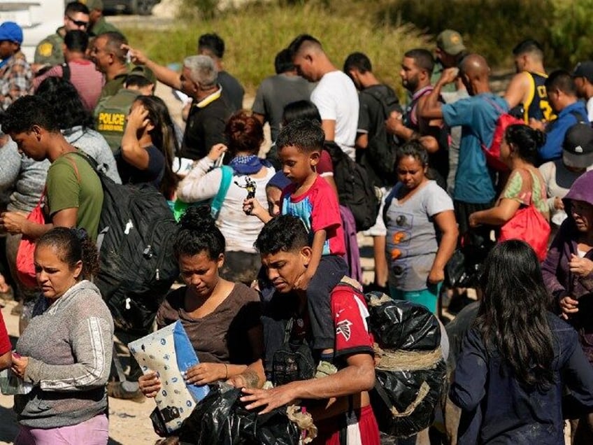 Migrants wait to be processed by the U.S. Customs and Border Patrol after they crossed the Rio Grande and entered the U.S. from Mexico, Thursday, Oct. 19, 2023, in Eagle Pass, Texas. Starting in March, Texas will give police even broader power to arrest migrants while also allowing local judges …