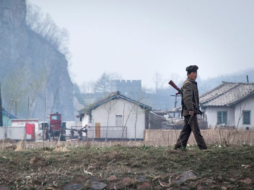 A North Korean soldier walks near the Yalu river near Sinuiju, opposite the Chinese border city of Dandong, on April 16, 2017. Dandong city is the main crossing point to North Korea, and every day hundreds of tourists embark on small boats for a cruise on the Yalu border river and a fleeting glimpse of another world. / AFP PHOTO / Johannes EISELE (Photo credit should read JOHANNES EISELE/AFP via Getty Images)