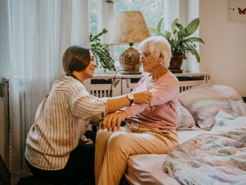 Female healthcare worker helping senior woman