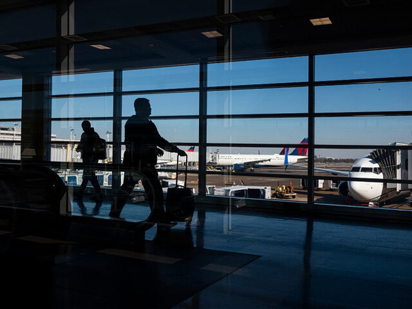 ARLINGTON, VIRGINIA - JANUARY 22: Travelers walk through the terminal at Ronald Reagan Was