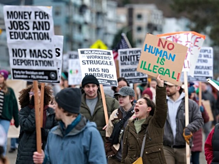 People hold signs during a march against Immigration and Customs Enforcement (ICE) entitle