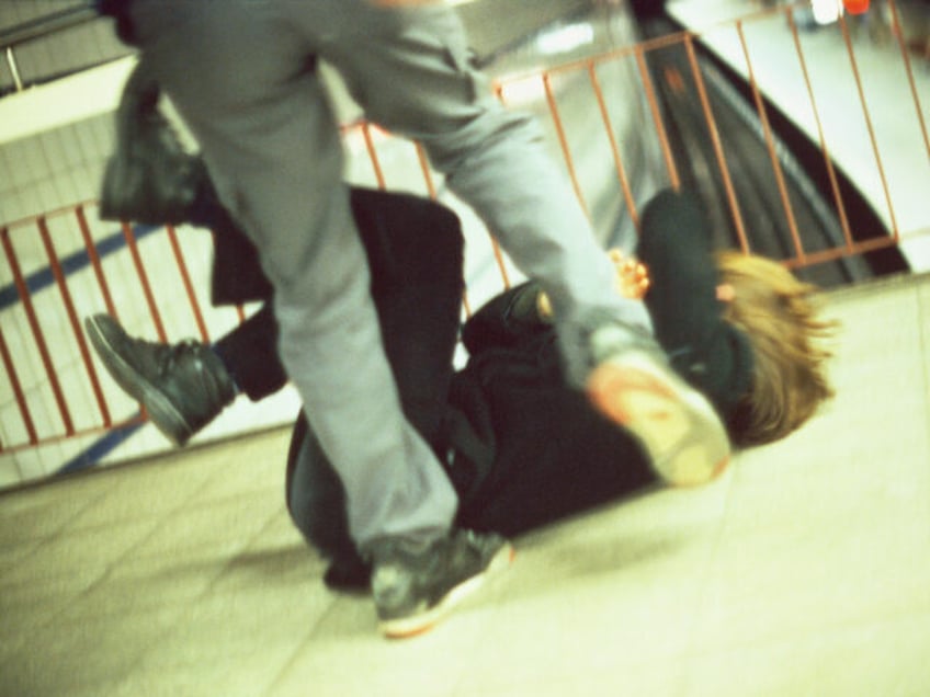 Man Kicking a Woman in Subway Station - stock photo