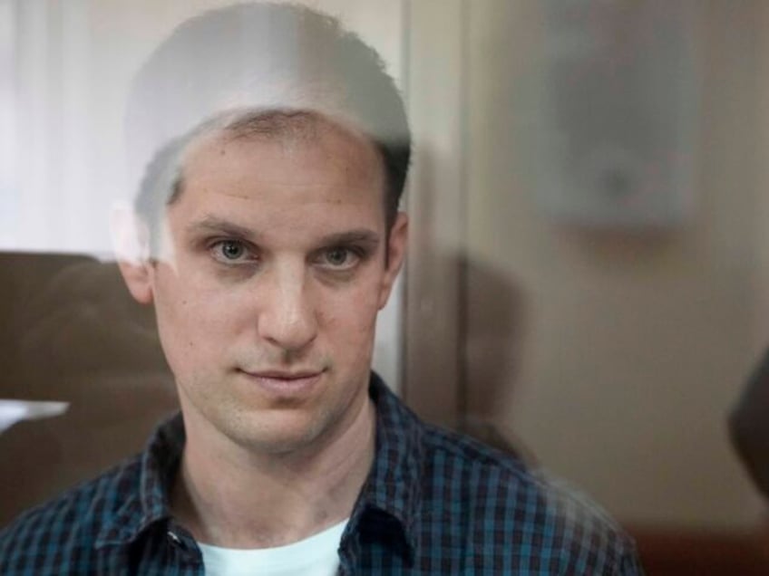 FIle - Wall Street Journal reporter Evan Gershkovich stands in a glass cage in a courtroom