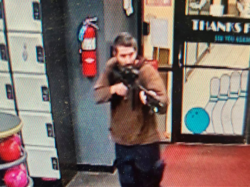 In this image taken from video released by the Androscoggin County Sheriff's Office, an unidentified gunman points a gun while entering Sparetime Recreation in Lewiston, Maine, on Wednesday, Oct. 25, 2023. Maine State Police ordered residents in the state's second-largest city to shelter in place Wednesday night as the suspect remains at large. (Androscoggin County Sheriff's Office via AP)