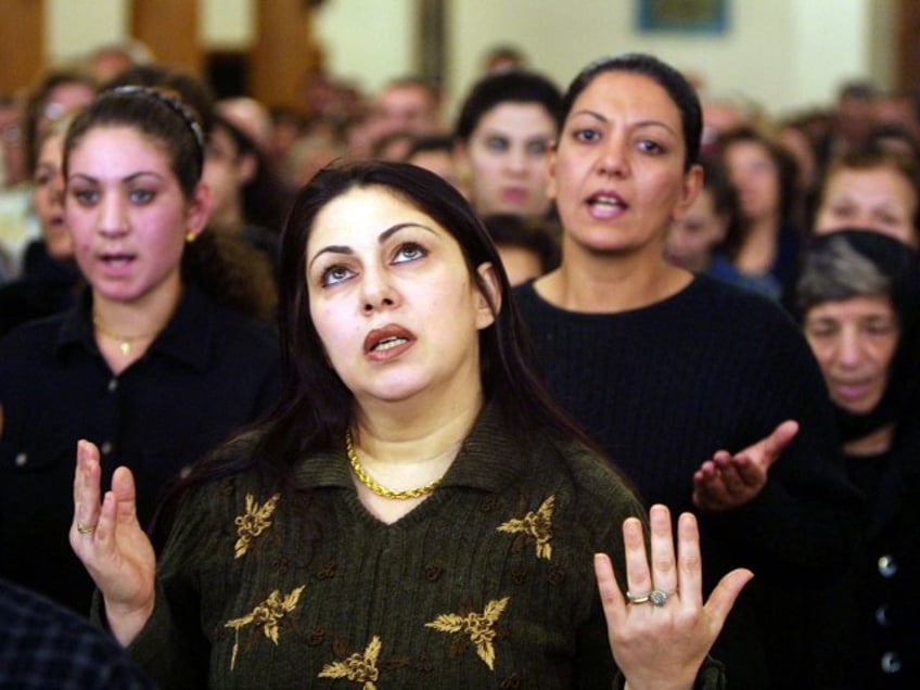 Iraqi Christians pray in a church, as all Christian denominations in Iraq prayed to prevent war on Iraq November 22, 2002 in Baghdad, Iraq. NATO members have declared themselves united in backing U.N. efforts to rid Iraq of weapons of mass destruction, but the 19-nation defense alliance stopped short of promising to go to war over it. (Photo by Salah Malkawi/Getty Images)