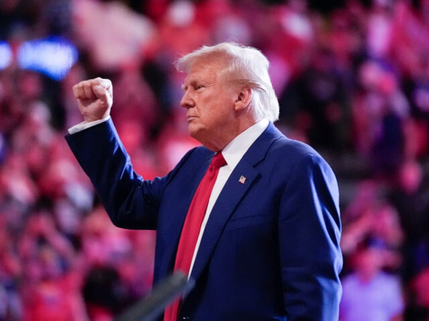 Republican presidential nominee former President Donald Trump raises his fist as he depart