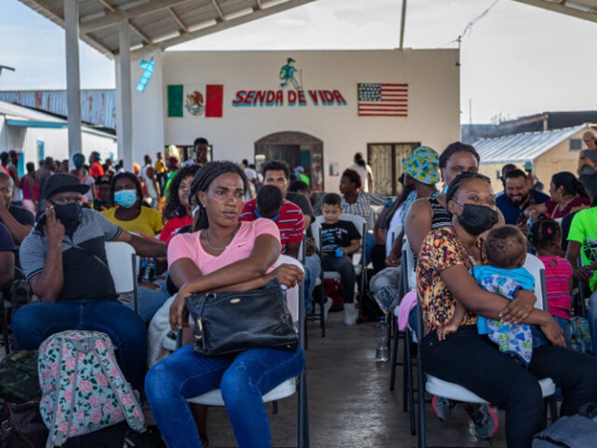 Migrants approved for humanitarian parole wait to board a bus taking migrants into the U.S