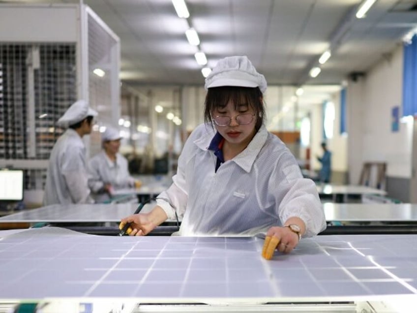 DONGYING, CHINA - MARCH 11: Employees work on the production line of solar panels at an in