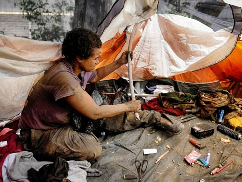 Suffering from homelessness Esca Guernon fixes her tent that's set up at an encampmen