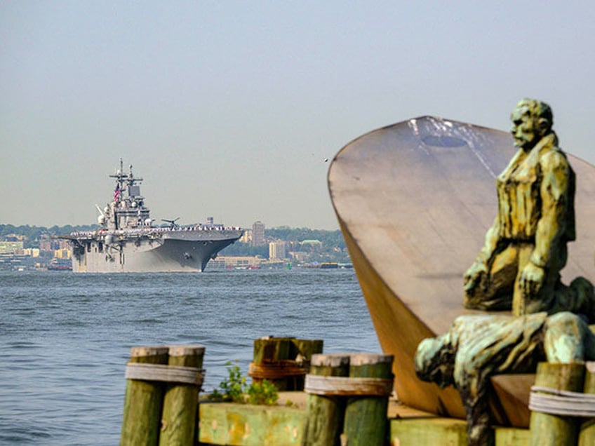 US Sailors and Marines stand on the flight deck of the USS Bataan, a Wasp-class amphibious