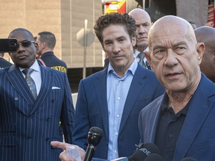 Lakewood Church pastor Joel Osteen, left center, listens as Mayor John Whitmire comments d