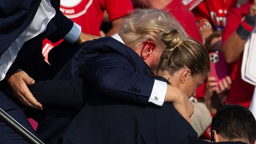 Former President Trump being taken off stage by Secret Service.