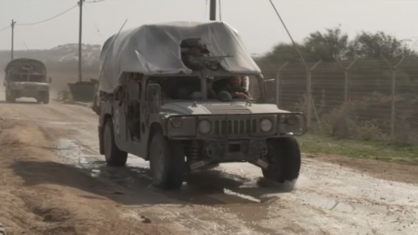 IDF military vehiclev driving on dirt road with soldiers