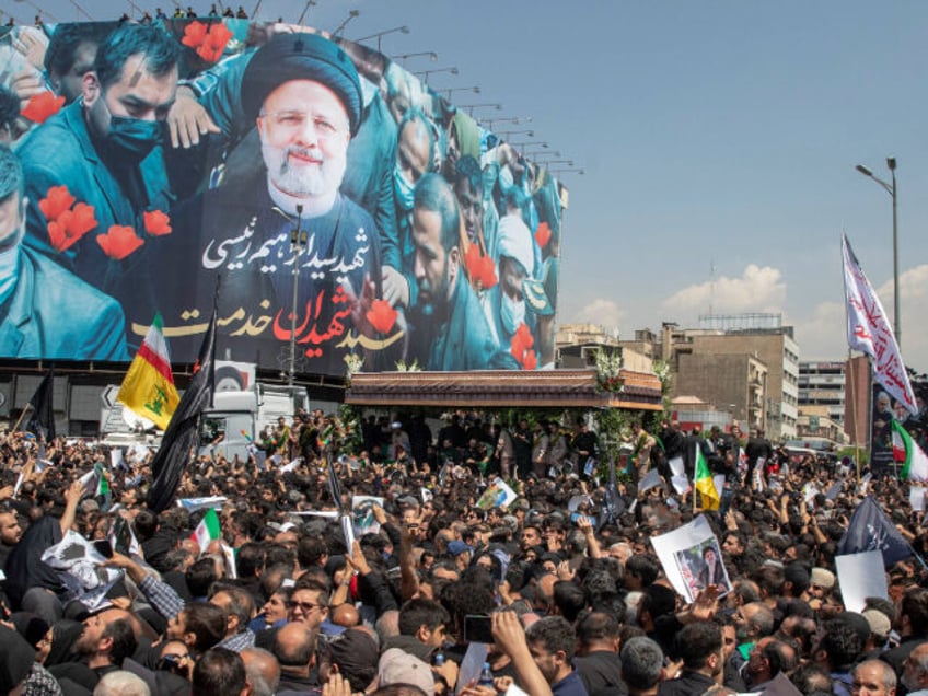 TEHRAN, IRAN - MAY 22: Iranians follow a truck carrying coffins of the late President Ebra