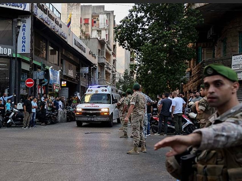 Lebanese army soldiers stand guard as an ambulance rushes wounded people to a hospital in