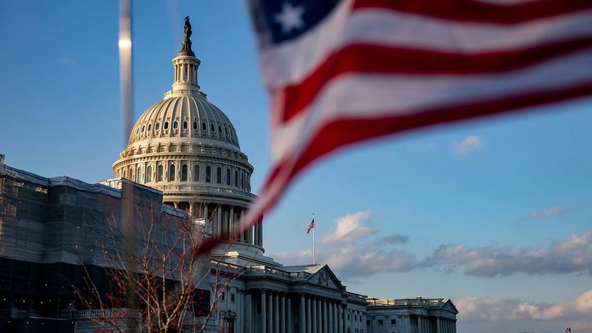 U.S. Capitol building and an American flag waving in front of it