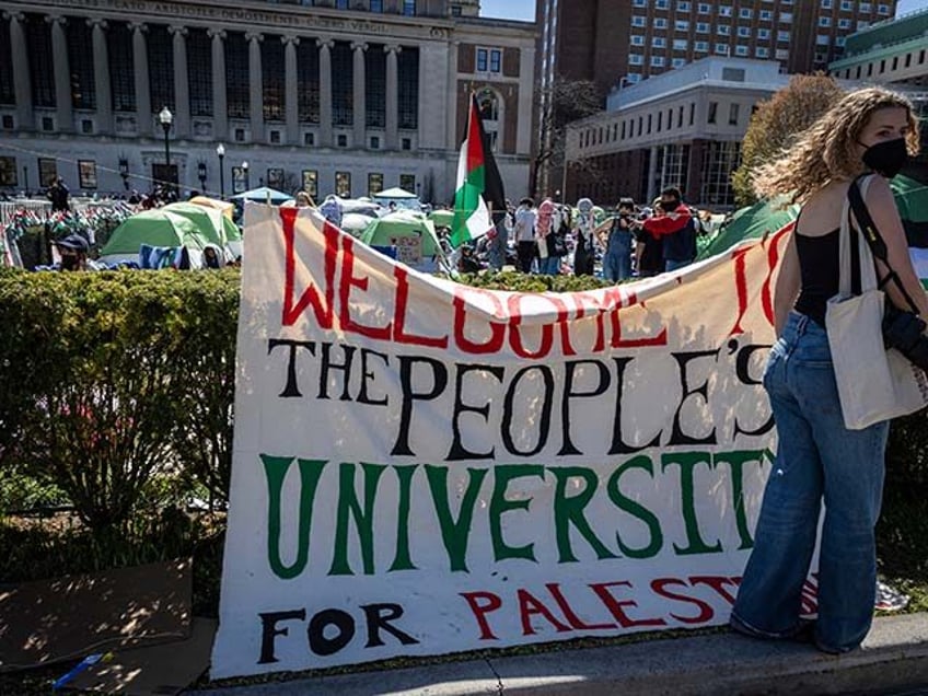 A sign is displayed in front of the tents erected at the pro-Palestinian demonstration enc