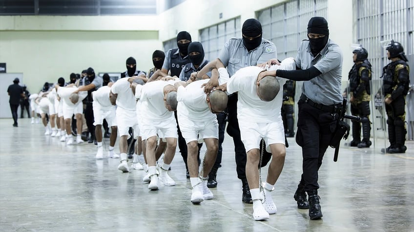 inmates at Salvadoran prison being marched in line by guards