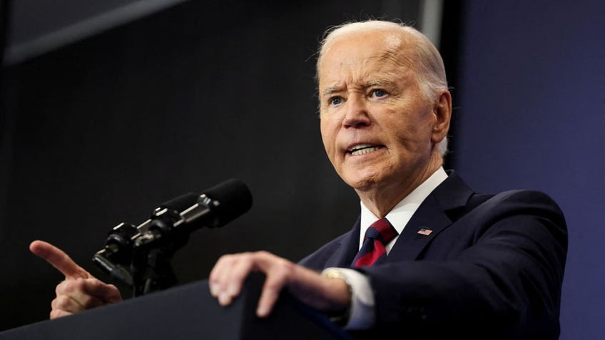 President Joe Biden gritting teeth at podium