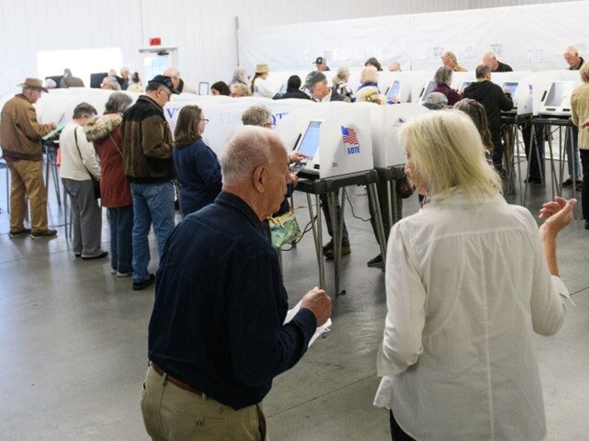 Poll workers help voters inside an early voting site on October 17, 2024 in Hendersonville