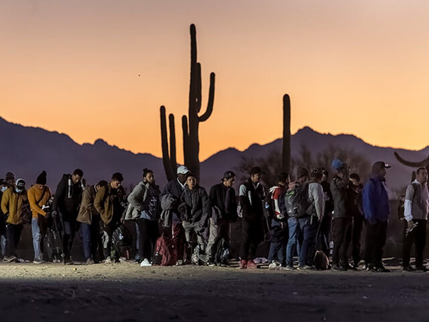 Immigrants line up at a remote U.S. Border Patrol processing center after crossing the U.S