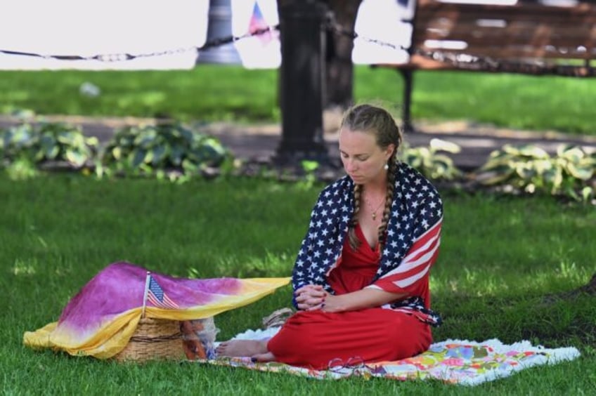 A person prays in a park in downtown Milwaukee, Wisconsin, on July 14, 2024 ahead of the R