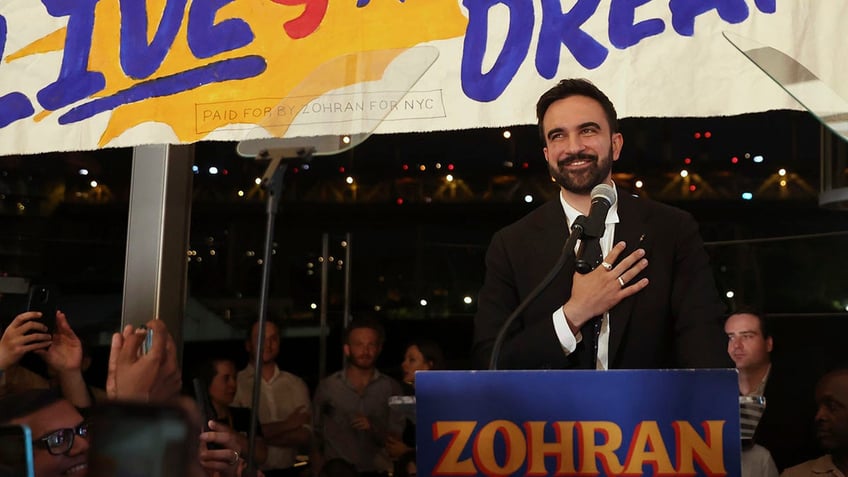 Zohran Mamdni at lectern at campaign rally
