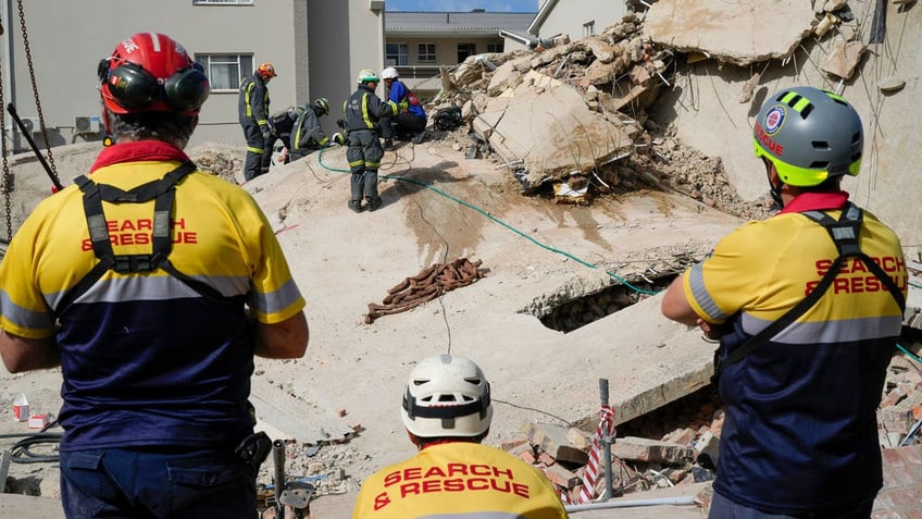 Rescue workers search the site of a building collapse