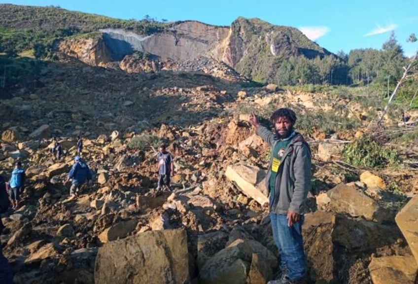 People gather at the site of a massive landslide in Papua New Guinea's Enga province