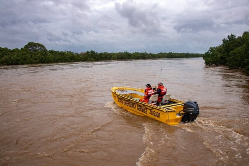 Flash floods swamped northeastern Australia on December 18, with raging waters severing roads and flushing crocodiles into towns