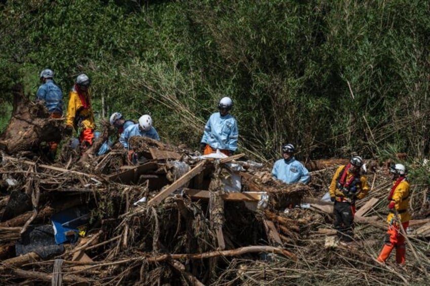 Rescuers combed the debris-strewn banks of a river in central Japan searching for flood vi