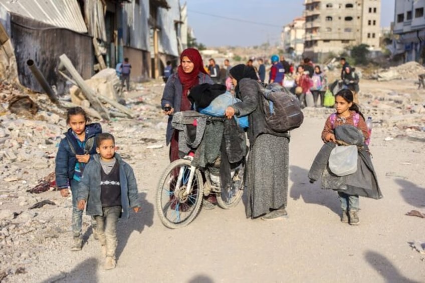 Displaced Palestinians fleeing Beit Lahia in northern Gaza walk on the main Salah al-Din R