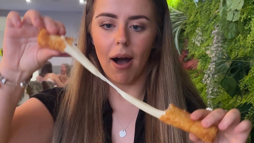 Grace Gonzalez pulling apart mozzarella stick.