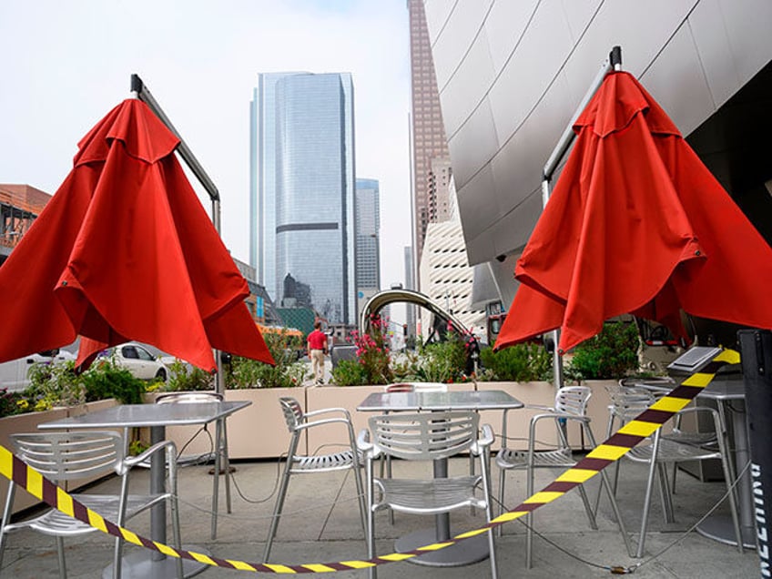 Caution tape surrounds closed outdoor restaurant cafe seating in front of the Walt Disney Concert Hall in downtown Los Angeles, California, on April 30, 2020. - A recent surge in the number of novel coronavirus cases and deaths linked to COVID-19 has brought California to two milestones, as the state …